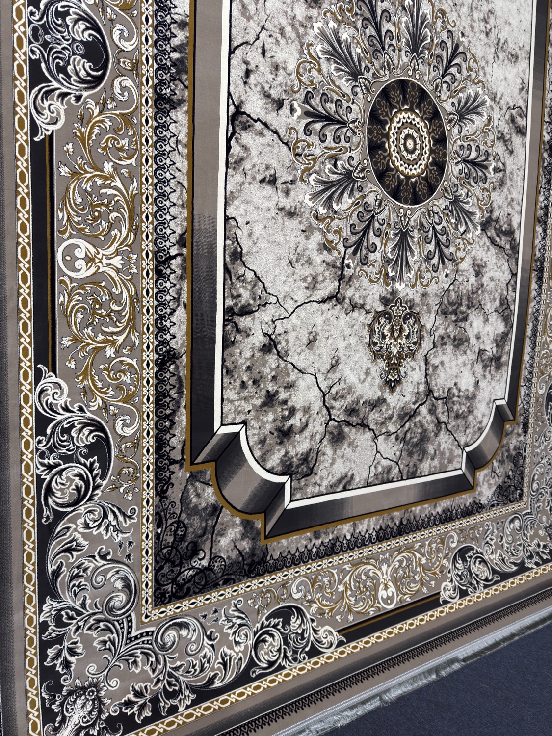 Persian rug in black, white and gold with ornate frame design